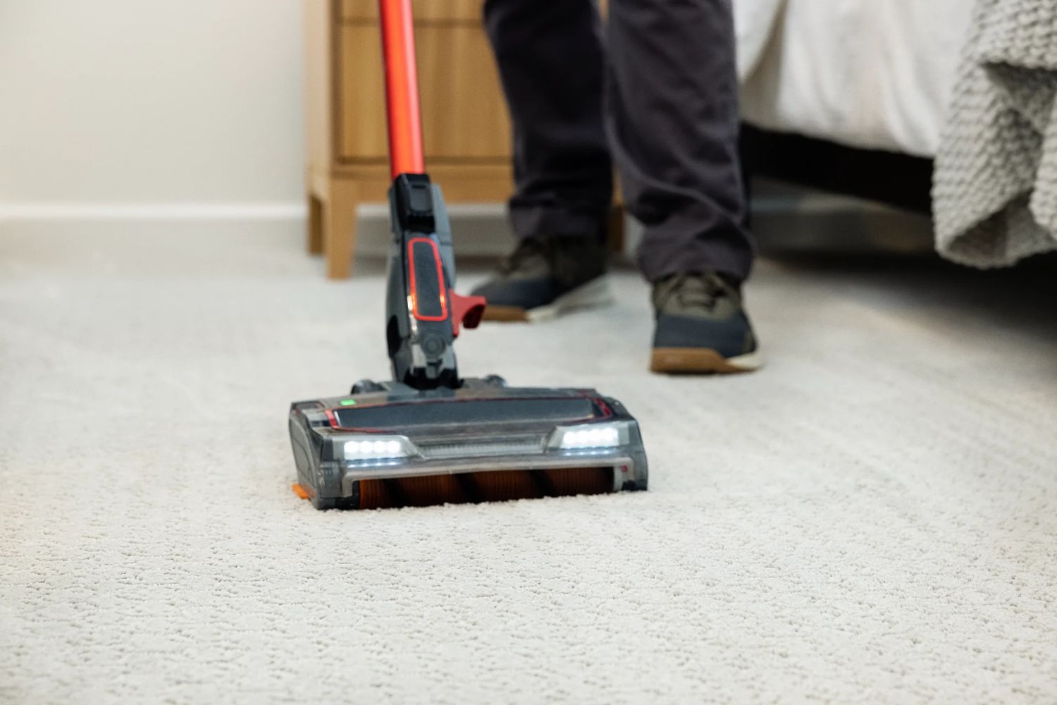 A person cleaning a carpet with a vacuum, highlighting a carpet cleaning service in Tampa, FL.